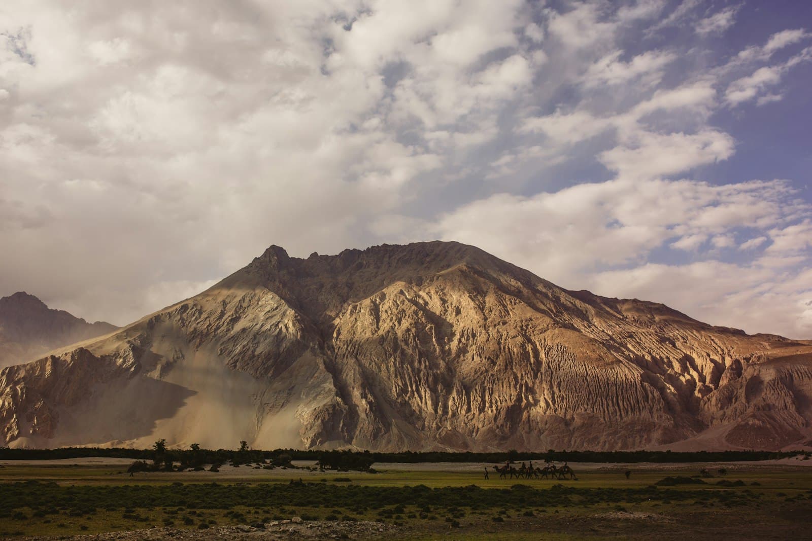 An arid trans-Himalayan valley of dust-coloured ridges under hazy light.
